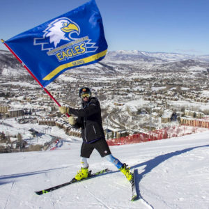 CMC Ski Team member waving team flag.